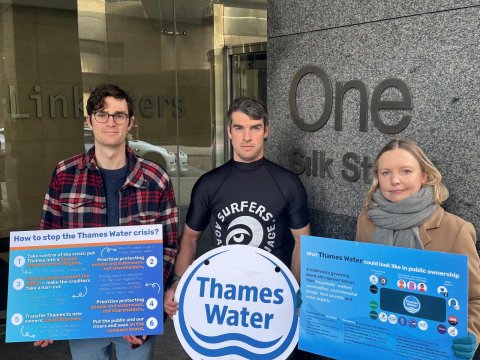 Protestors present alternative plan for Thames Water! Imamge shows three protestors outside Linklatters law offices holding boards presenting information on what should happen next to Thames Water