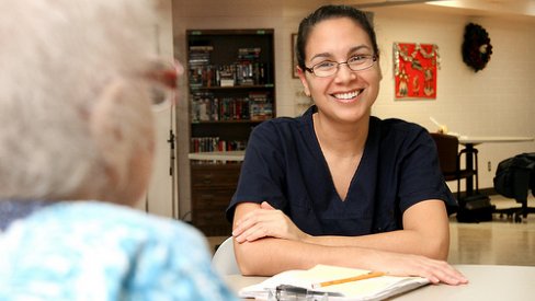 Photo of care assistant talking to older person